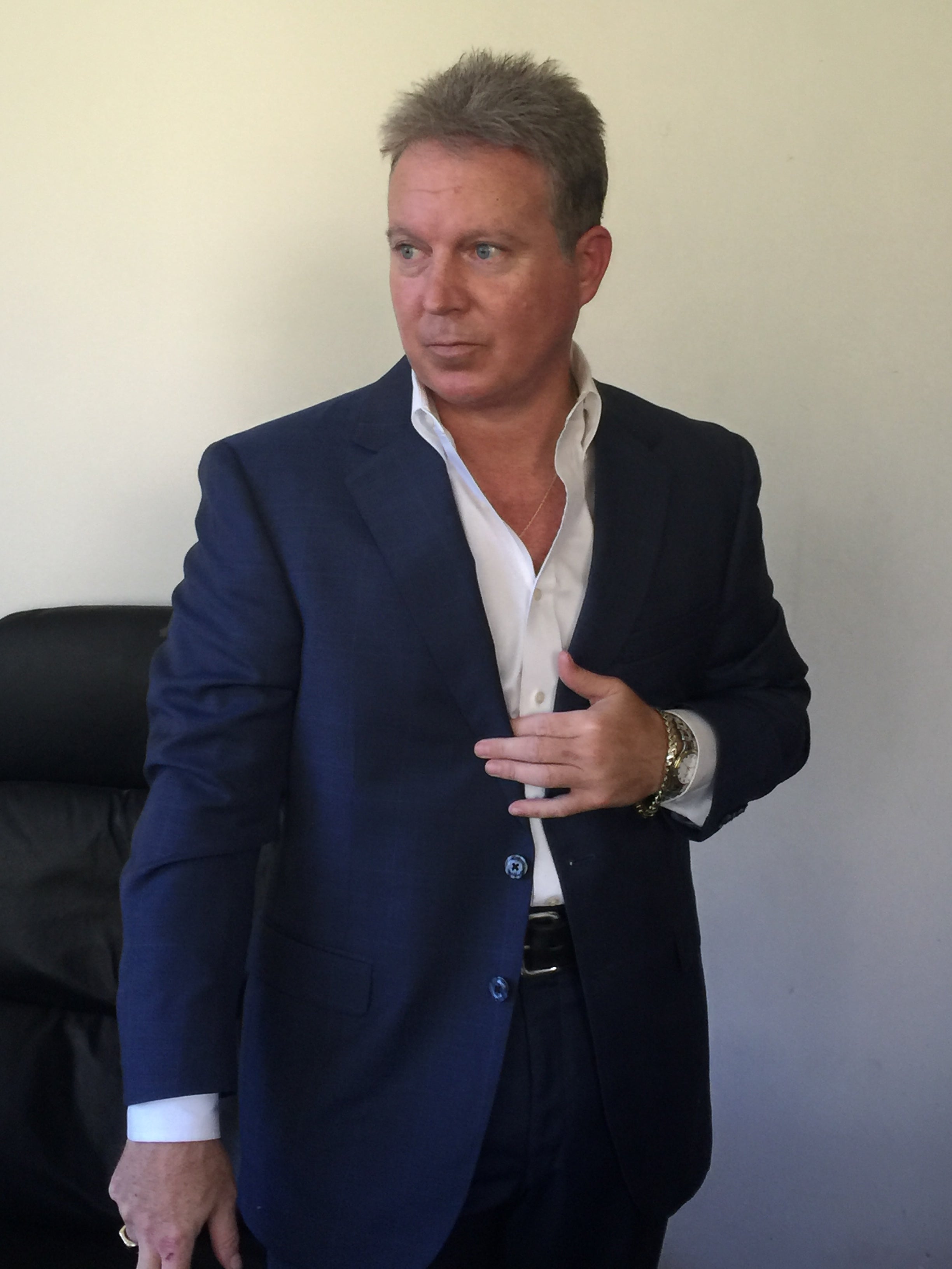 Professional portrait of Eric Smith in a blue suit and white shirt, exuding confidence in a business setting.